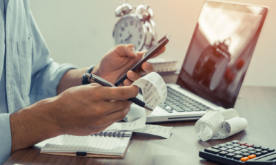 A man uses a calculator and software to work out his VAT bill