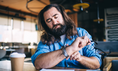 A sole trader checks the date on his watch