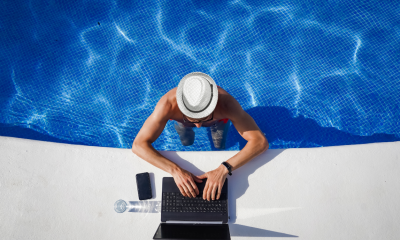 Man working on his laptop from a swimming pool