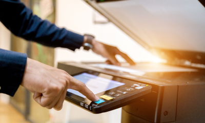 A man uses a well-stocked printer in the office