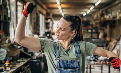A female construction worker flexes her muscles