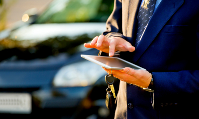 Car finance Person holding car keys and tapping on tablet
