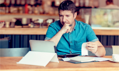 A worried man looks at his rising bills and costs