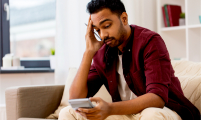 A young Asian man worries about how he will pay his self assessment tax bill