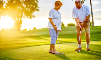 A couple are enjoying their retirement playing golf together in the sunshine