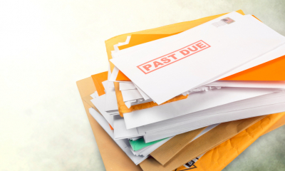A pile of unpaid bills sits on a table