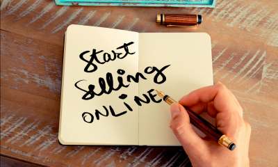 Person holding a pen with 'start selling online' written in the middle of a notebook