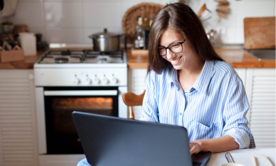 Young woman working from home office in a cozy kitchen