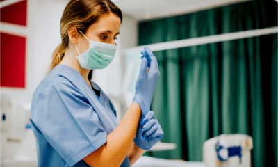 A nurse is putting on surgical gloves