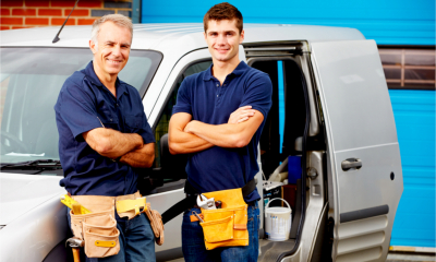 A father and son stand next the the family business van