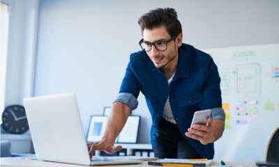 Freelancer at work using both his laptop and mobile