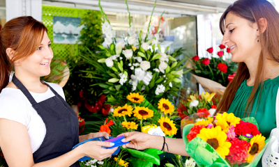 A female customer pays for her flowers in a florists using a card payment