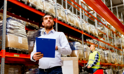 Import and export finance Man checking stock in large logistics warehouse