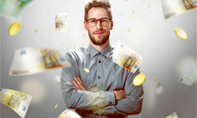 Attractive young business man surrounded by money that is raining down