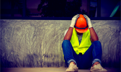 A building contractor holds his head in his hands