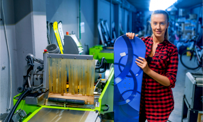 A woman uses the equipment she is leasing to make a snowboard
