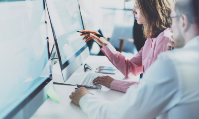 Two people in shirts sat at a computer managing IT-related risks