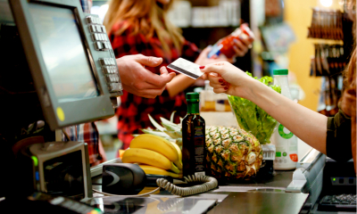 Man purchasing food at a supermarket using his credit card