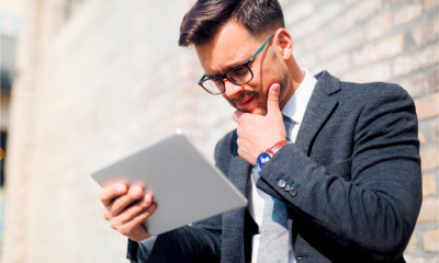 A confused man looks at his tablet device