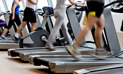A group of runners on treadmills, waist down shot of their legs in motion