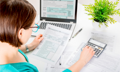 A small business owner fills in her Self Assessment tax return, using a calculator to work out key figures.