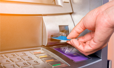A man withdraws money from his personal bank account using a cashpoint machine