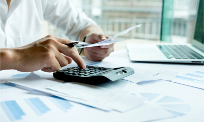 A man is paying his business invoices and expenses