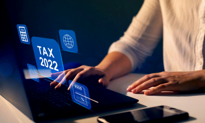 Woman's hands on laptop with 'Tax 2022' text on