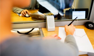 Woman signing an application form for a personal bank account