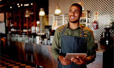 Café owner smiling as he takes advantages of tax breaks for employers