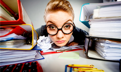 Woman business owner searching for tax records in files and paperwork