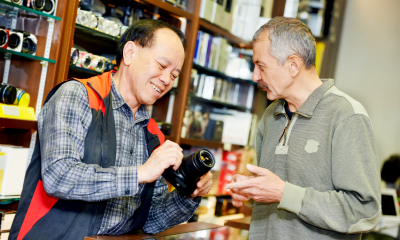 A small business confidently sells camera equipment knowing he is covered by his insurance policy