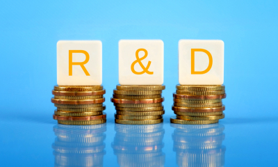 Three piles of coins with R&D balanced on top