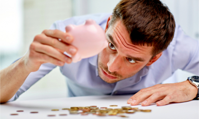 A self employed man checks his money box for savings