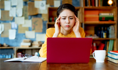 Stressed, young self employed asian woman working at home.