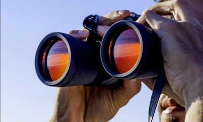 Person looking through orange tinted binoculars