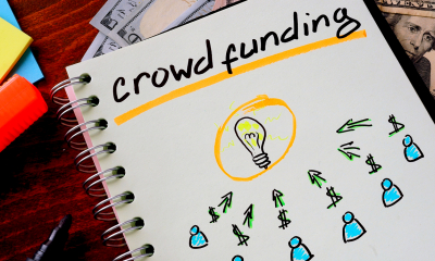 Notepad with 'crowd funding' written on the front cover with drawings below