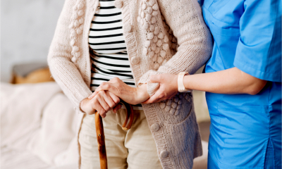 A nurse supports and elderly patient