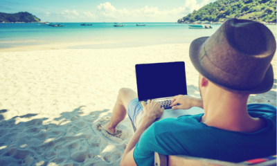 Young man working on a beach in Thailand as a freelancer