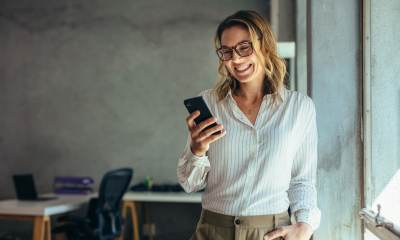 Woman wearing glasses using her mobile phone to access 4G coverage